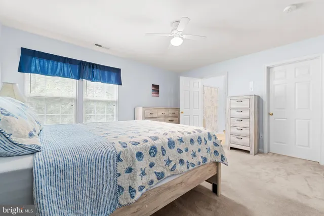 a bedroom with a bed a window and dresser