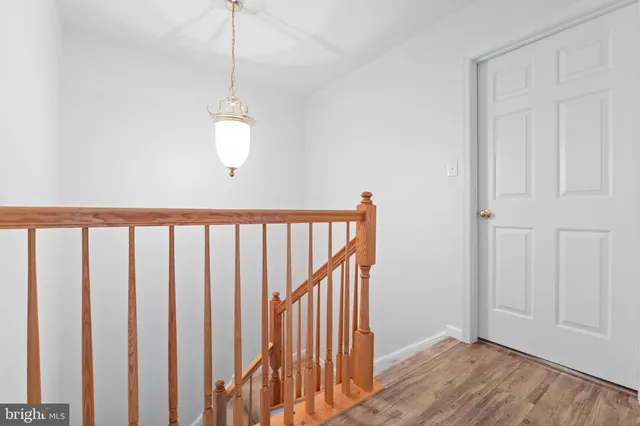 a view of a hallway with wooden floor and staircase
