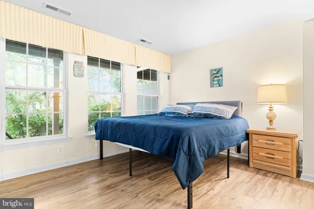 a bedroom with a bed and a dresser next to a window