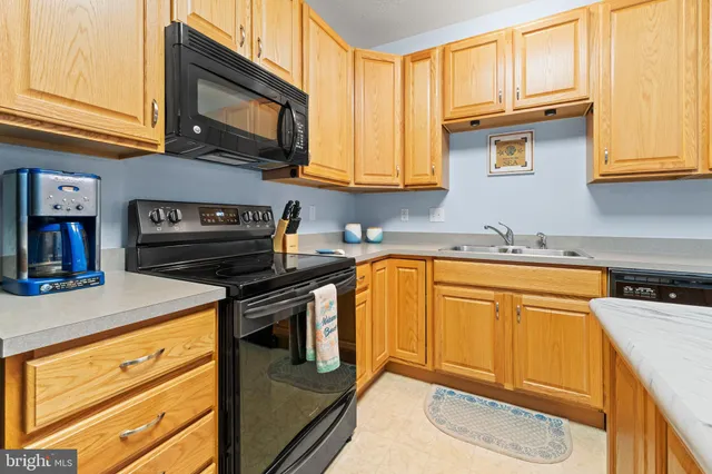 a kitchen with stainless steel appliances granite countertop a sink a stove and cabinets