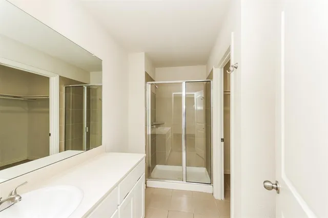 a en suite bathroom with a shower sink and mirror
