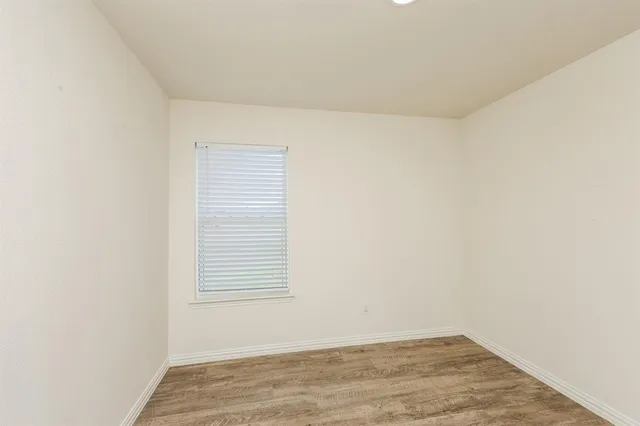 a view of a small space with wooden floor and a window