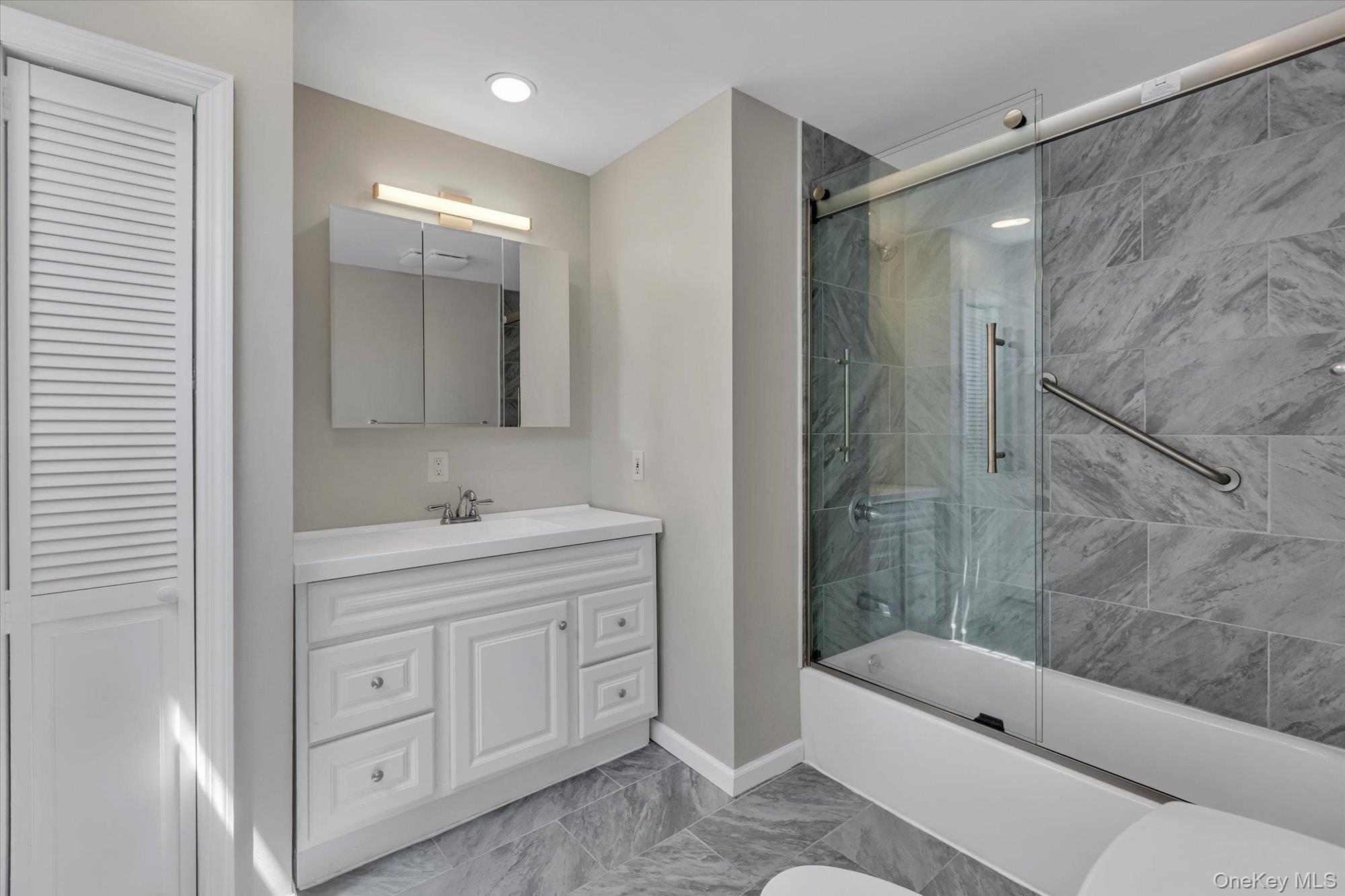 24 Milton Road Babylon, NY 11702 - Photo 6 of 30 a bathroom with a tub a sink a mirror a shower and vanity