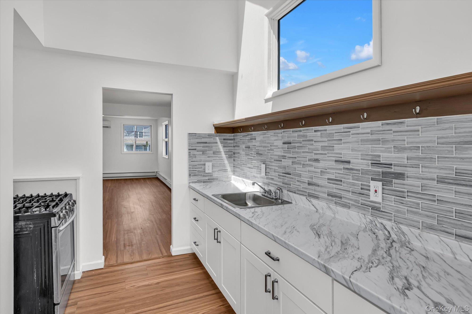 24 Milton Road Babylon, NY 11702 - Photo 8 of 30 a kitchen with granite countertop white cabinets and stainless steel appliances