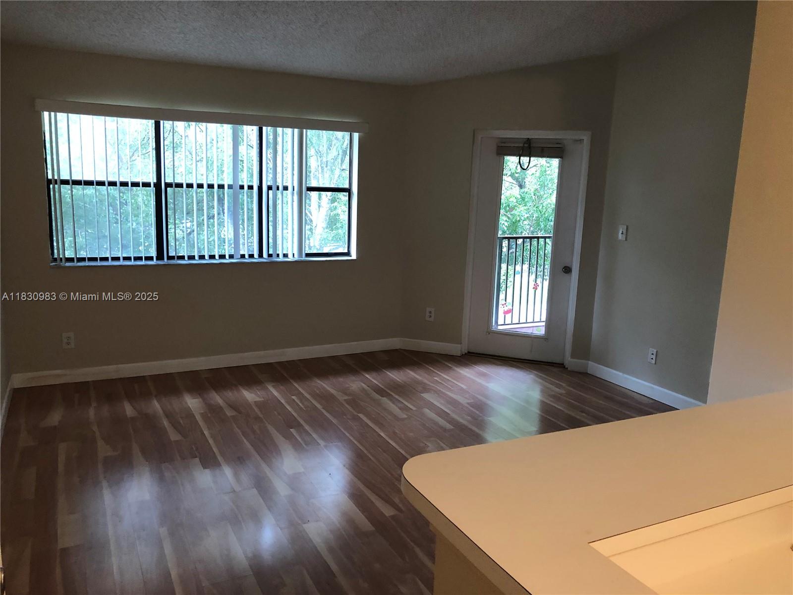 620 South Park Road, Unit 332 Hollywood, FL 33021 - Photo 2 of 6 an empty room with wooden floor and windows