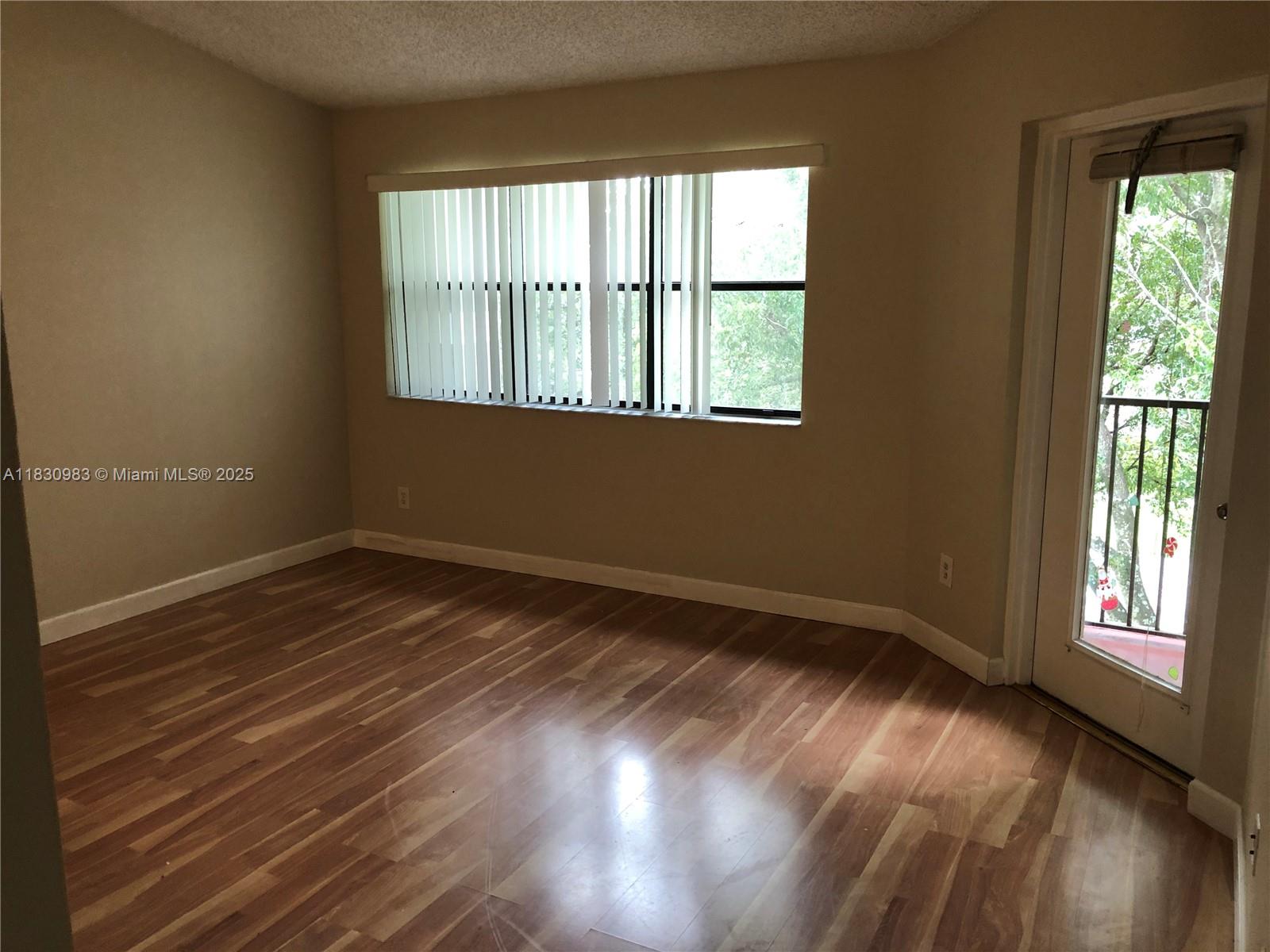 620 South Park Road, Unit 332 Hollywood, FL 33021 - Photo 6 of 6 a view of an empty room with wooden floor and a window