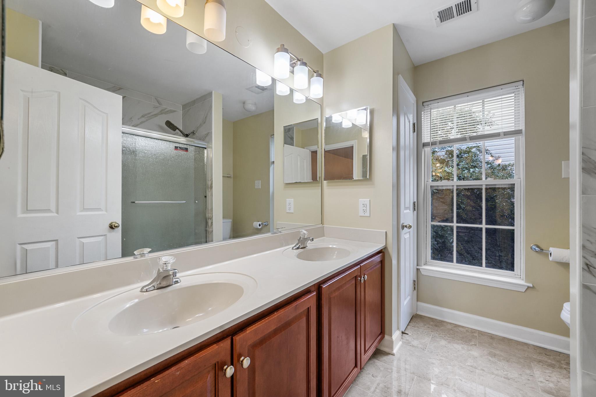 6514 Manton Way Lanham, MD 20706 - Photo 17 of 24 a bathroom with a granite countertop sink a large mirror and a shower