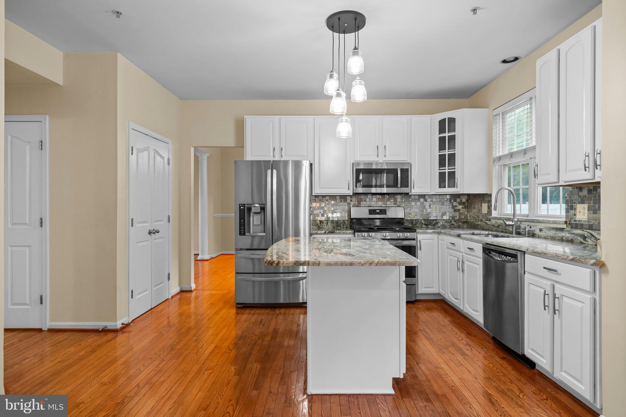 6514 Manton Way Lanham, MD 20706 - Photo 8 of 24 a kitchen with stainless steel appliances kitchen island granite countertop a refrigerator a stove and white cabinets with wooden floor