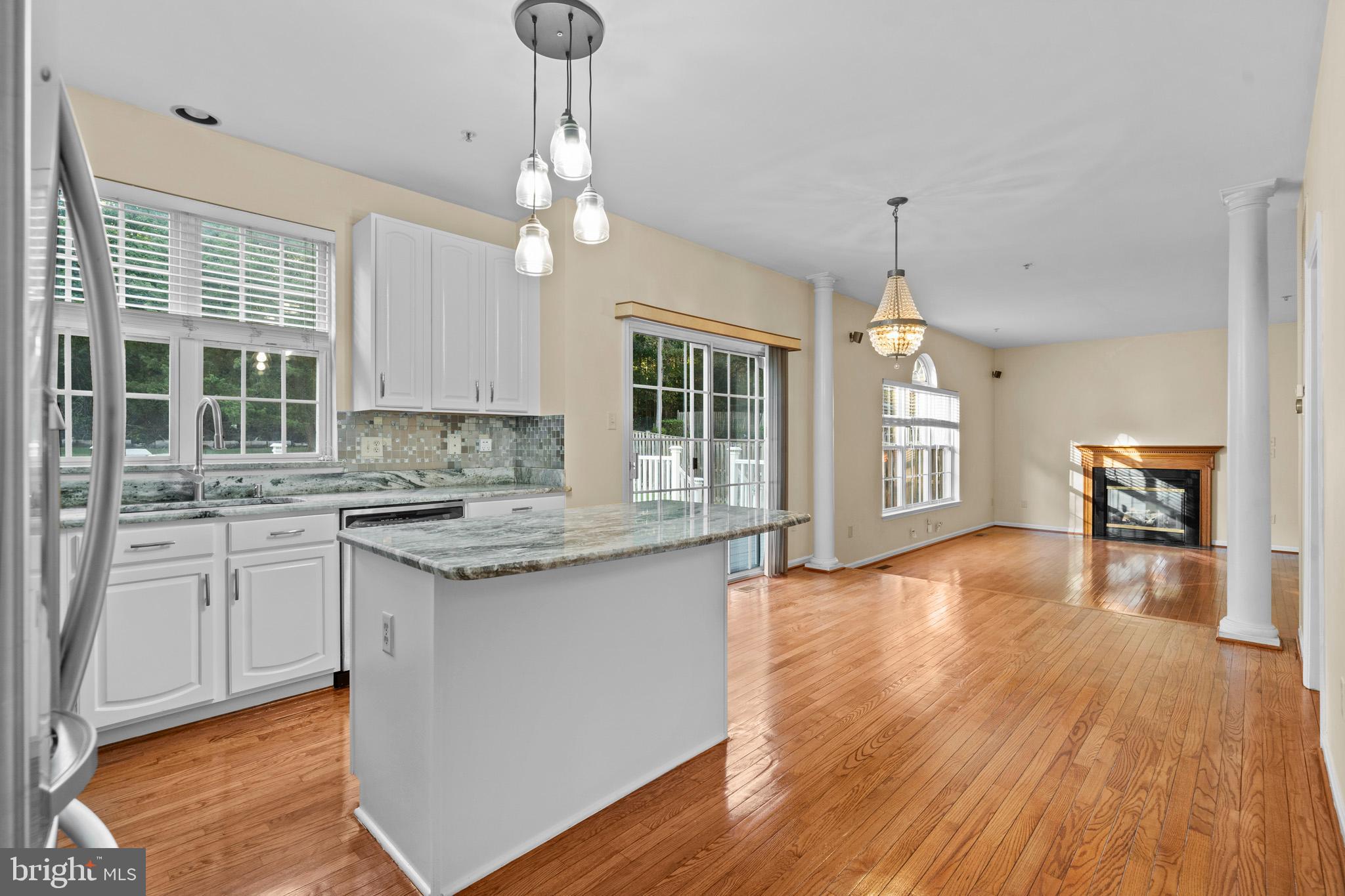 6514 Manton Way Lanham, MD 20706 - Photo 10 of 24 a kitchen with granite countertop a stove a sink wooden floor dining table and chairs