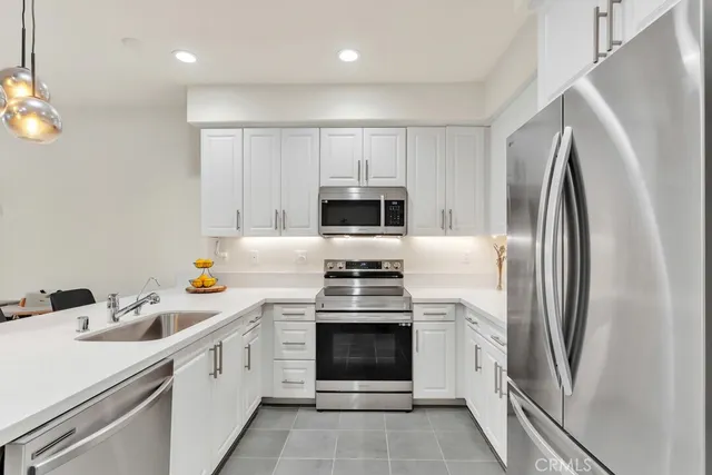 a kitchen with white cabinets and stainless steel appliances