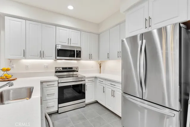 a kitchen with cabinets stainless steel appliances and a counter space