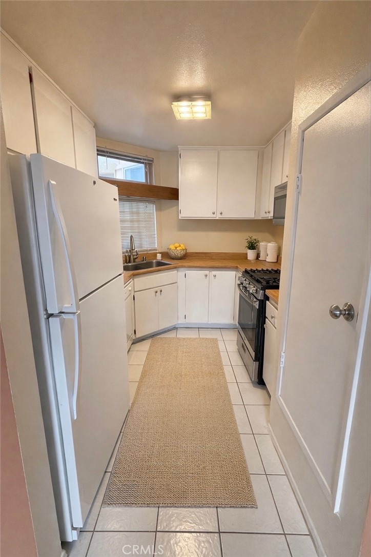1766 Sinaloa Road, Unit 177 Simi Valley, CA 93065 - Photo 3 of 13 a kitchen with stainless steel appliances granite countertop a refrigerator and a stove