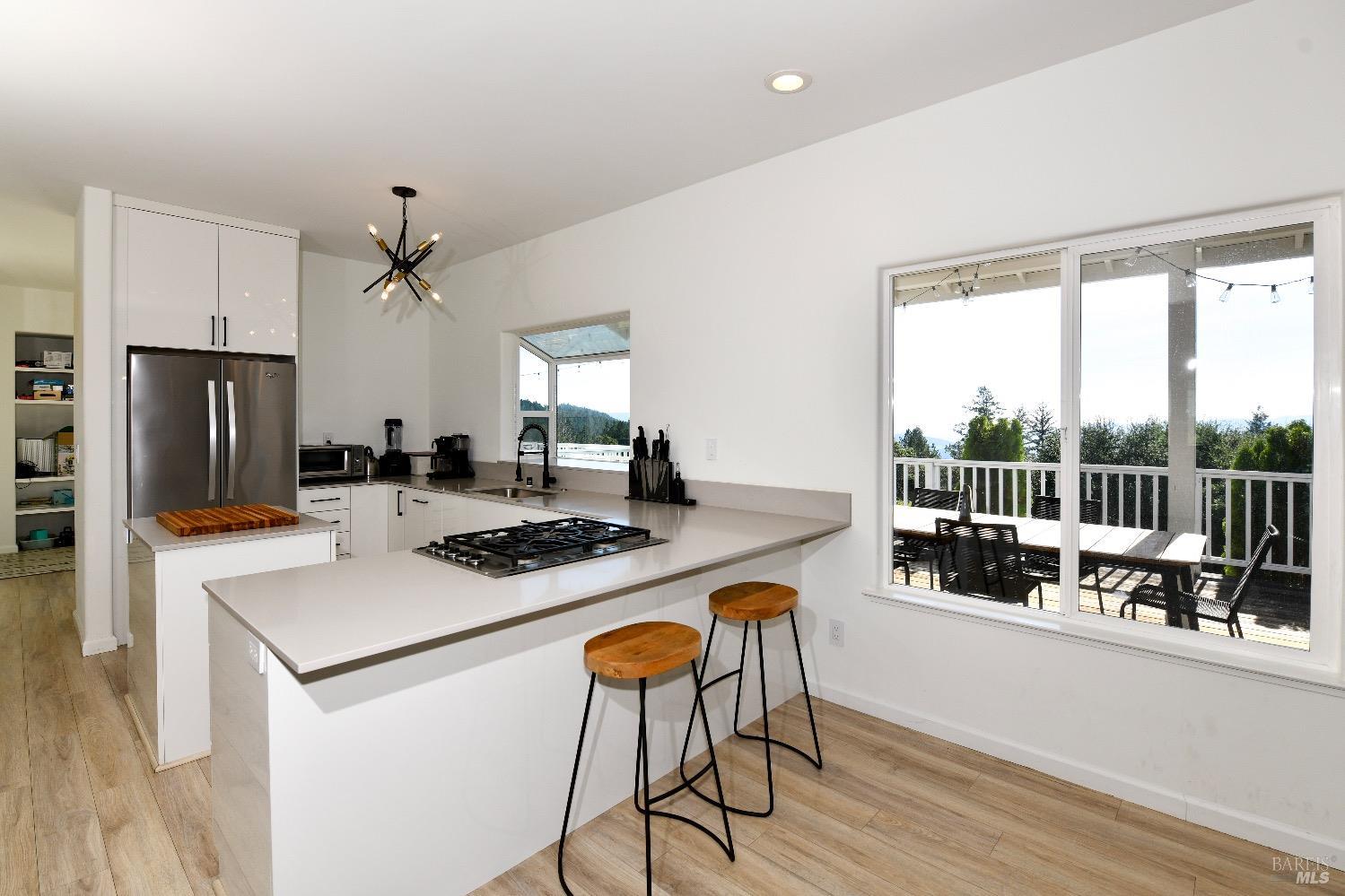 540 Edgemont Lane Angwin, CA 94508 - Photo 14 of 40 a kitchen with a stove a refrigerator and a dining table with wooden floor