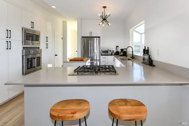 a kitchen with stainless steel appliances granite countertop a sink a stove and a refrigerator