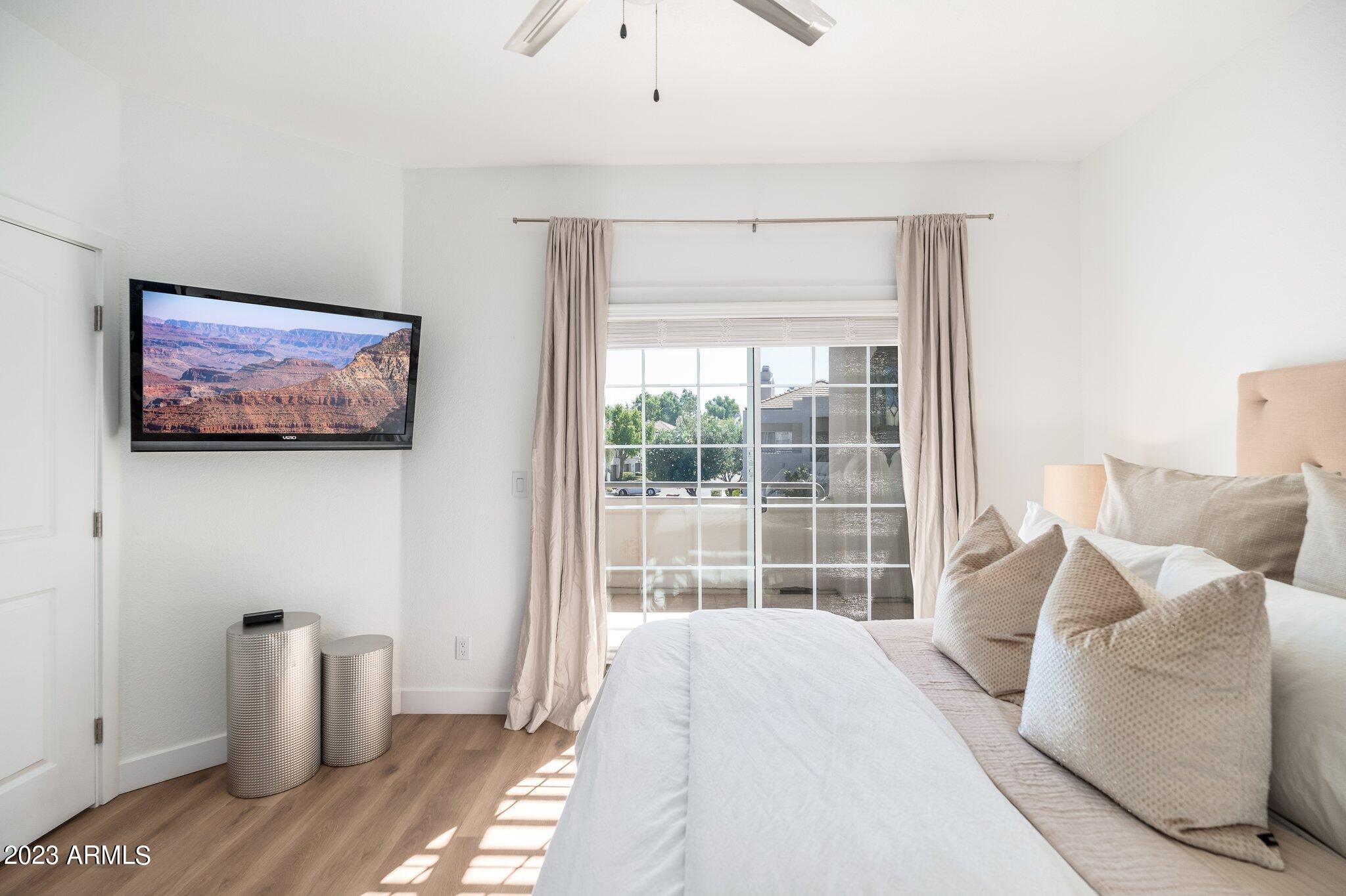7710 East Gainey Ranch Road, Unit 259 Scottsdale, AZ 85258 - Photo 21 of 48 a bedroom with a bed and wooden floor