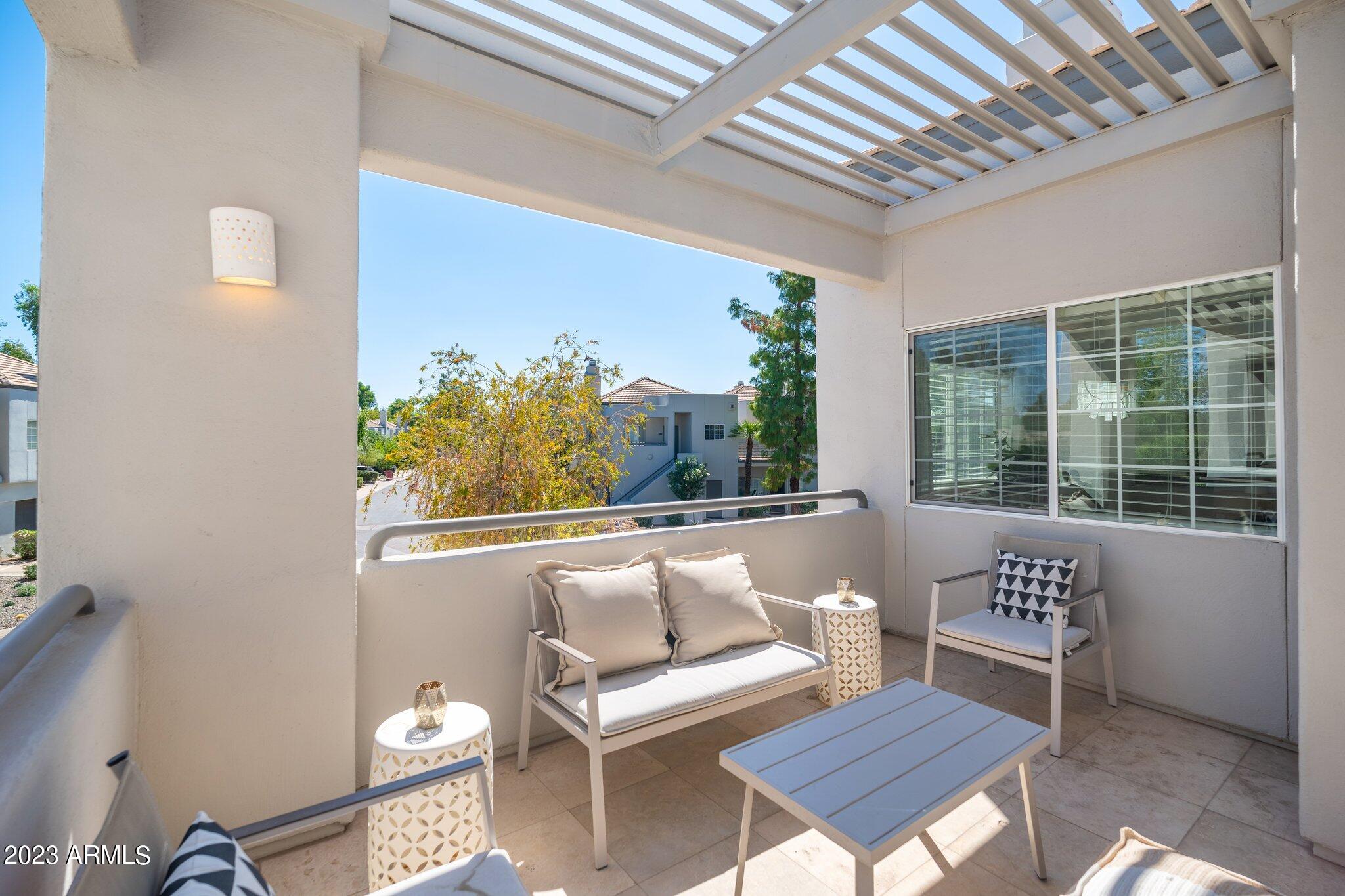 7710 East Gainey Ranch Road, Unit 259 Scottsdale, AZ 85258 - Photo 3 of 48 a balcony with furniture and a potted plant