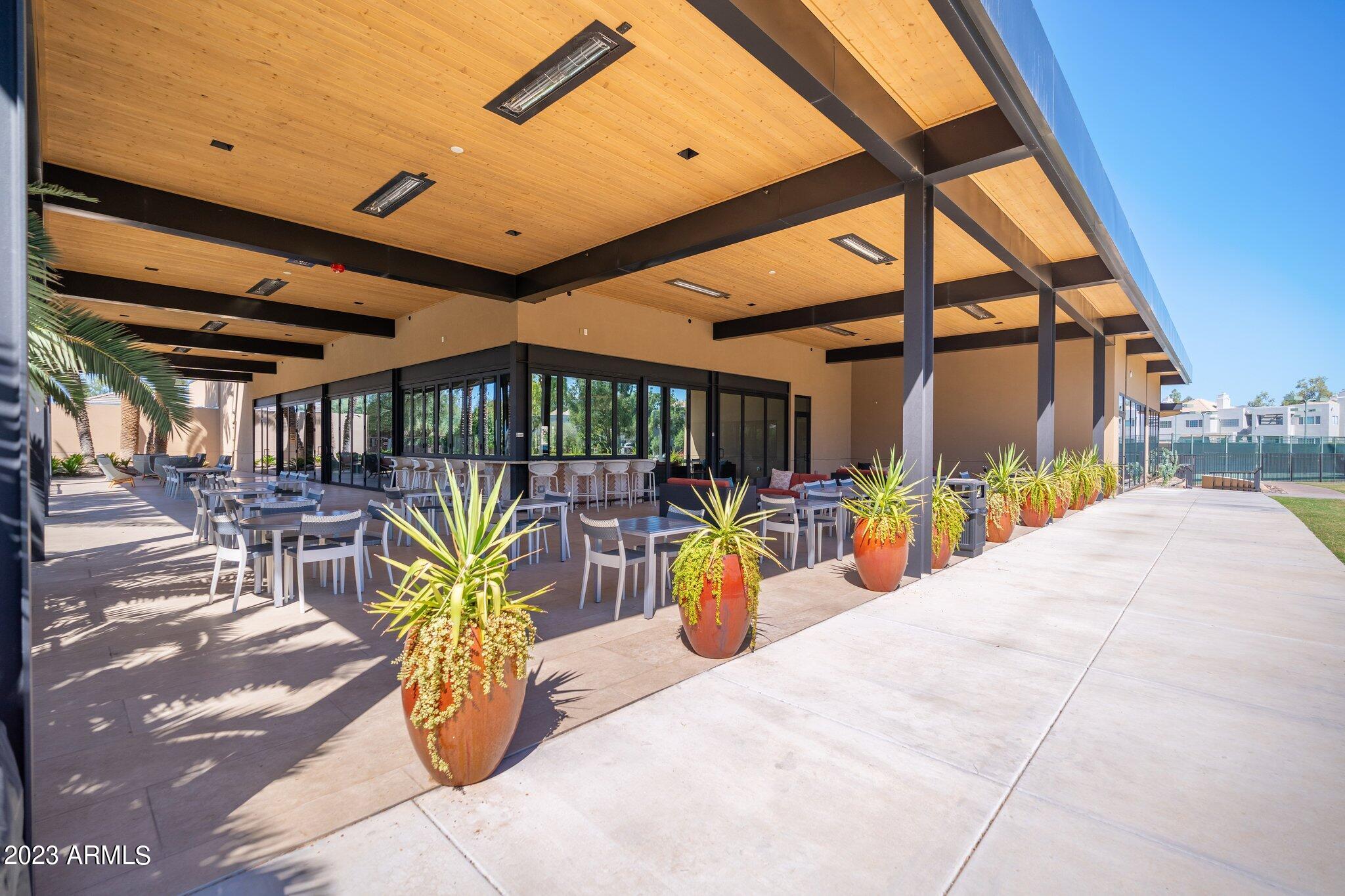 7710 East Gainey Ranch Road, Unit 259 Scottsdale, AZ 85258 - Photo 32 of 48 a view of a patio with a dining table and chairs under an umbrella