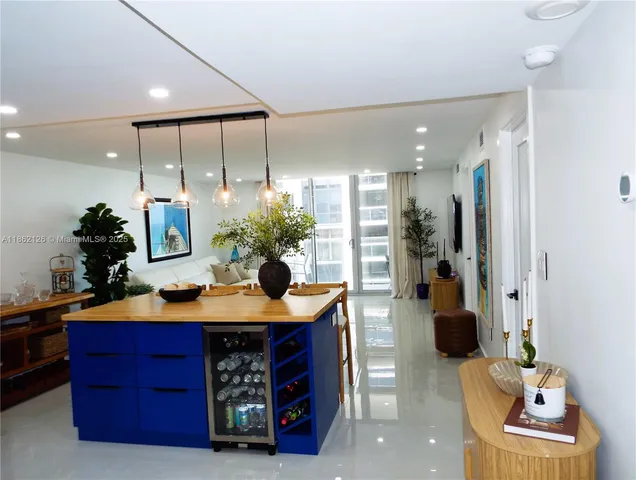 a kitchen with stainless steel appliances kitchen island granite countertop a sink and a refrigerator