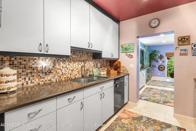 a kitchen with white cabinets and sink