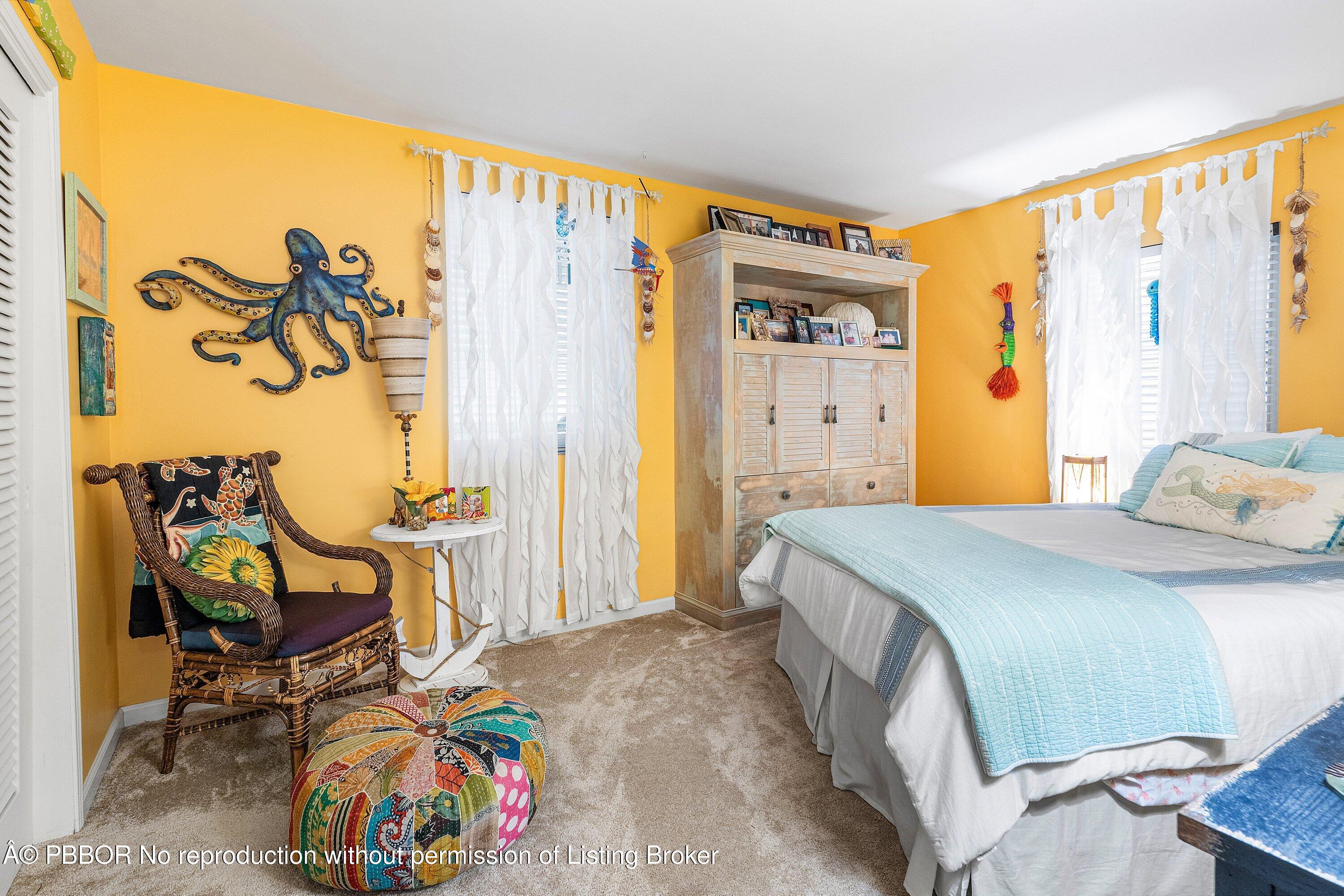 110 Dolphin Road Ocean Ridge, FL 33435 - Photo 16 of 33 a bedroom with a bed a table and a painting on the wall