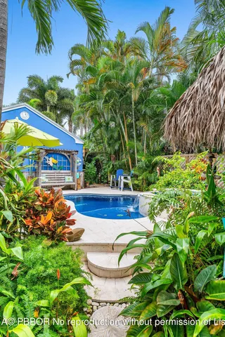 a view of swimming pool with a garden and plants