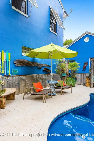 a view of a patio with a table and chairs under an umbrella
