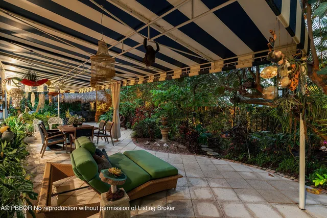 a view of patio with table and chairs potted plants and large tree