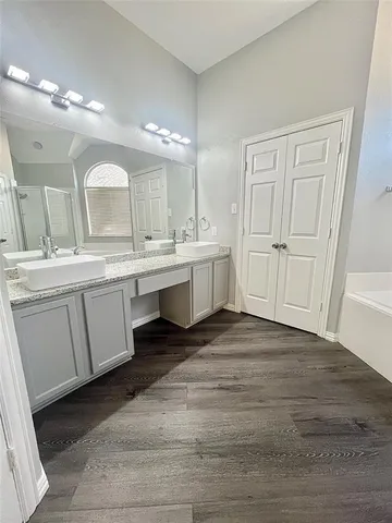 a spacious bathroom with a double vanity sink and mirror
