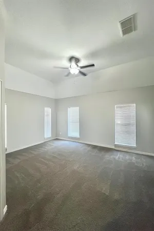 a view of an empty room with a ceiling fan