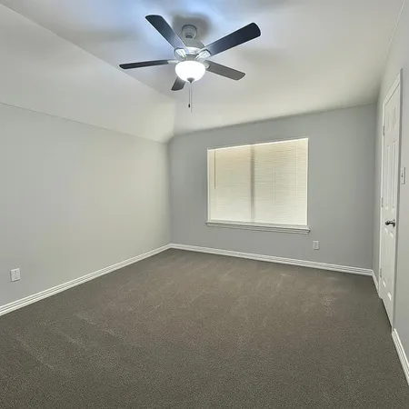 an empty room with a window and a fan