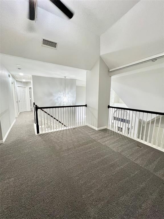 5729 Christy Lane Haltom City, TX 76137 - Photo 17 of 24 Empty room featuring carpet floors, a textured ceiling, attic access, a chandelier, and ceiling fan