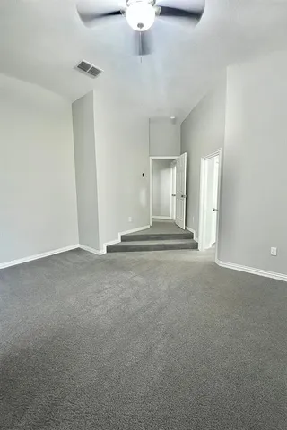 a view of a livingroom with a fireplace a chandelier fan and windows