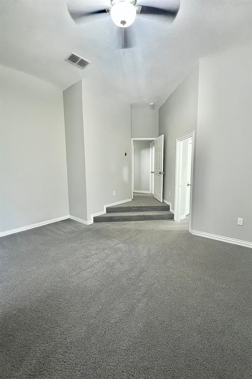 5729 Christy Lane Haltom City, TX 76137 - Photo 23 of 24 Empty room featuring dark colored carpet, a textured ceiling, and a ceiling fan