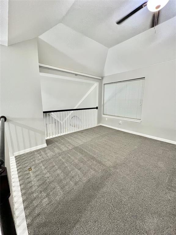 5729 Christy Lane Haltom City, TX 76137 - Photo 24 of 24 Empty room featuring carpet, a textured ceiling, lofted ceiling, and a ceiling fan