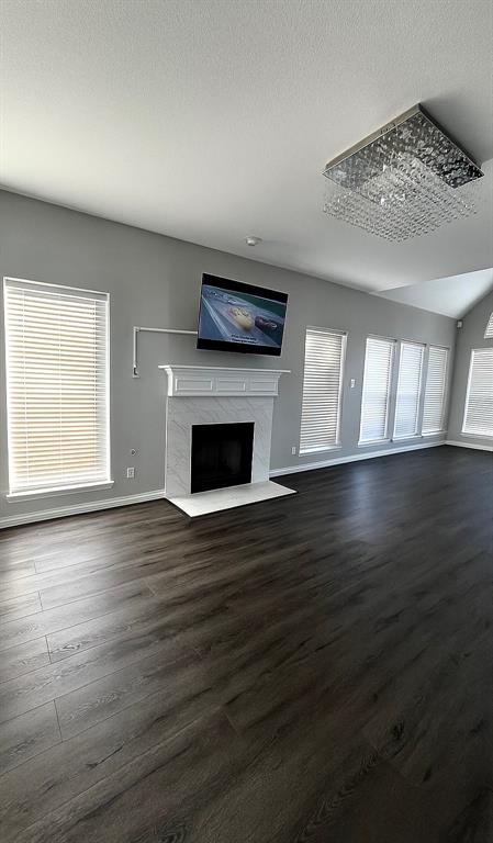 5729 Christy Lane Haltom City, TX 76137 - Photo 5 of 24 Unfurnished living room featuring a fireplace, dark wood finished floors, and a textured ceiling