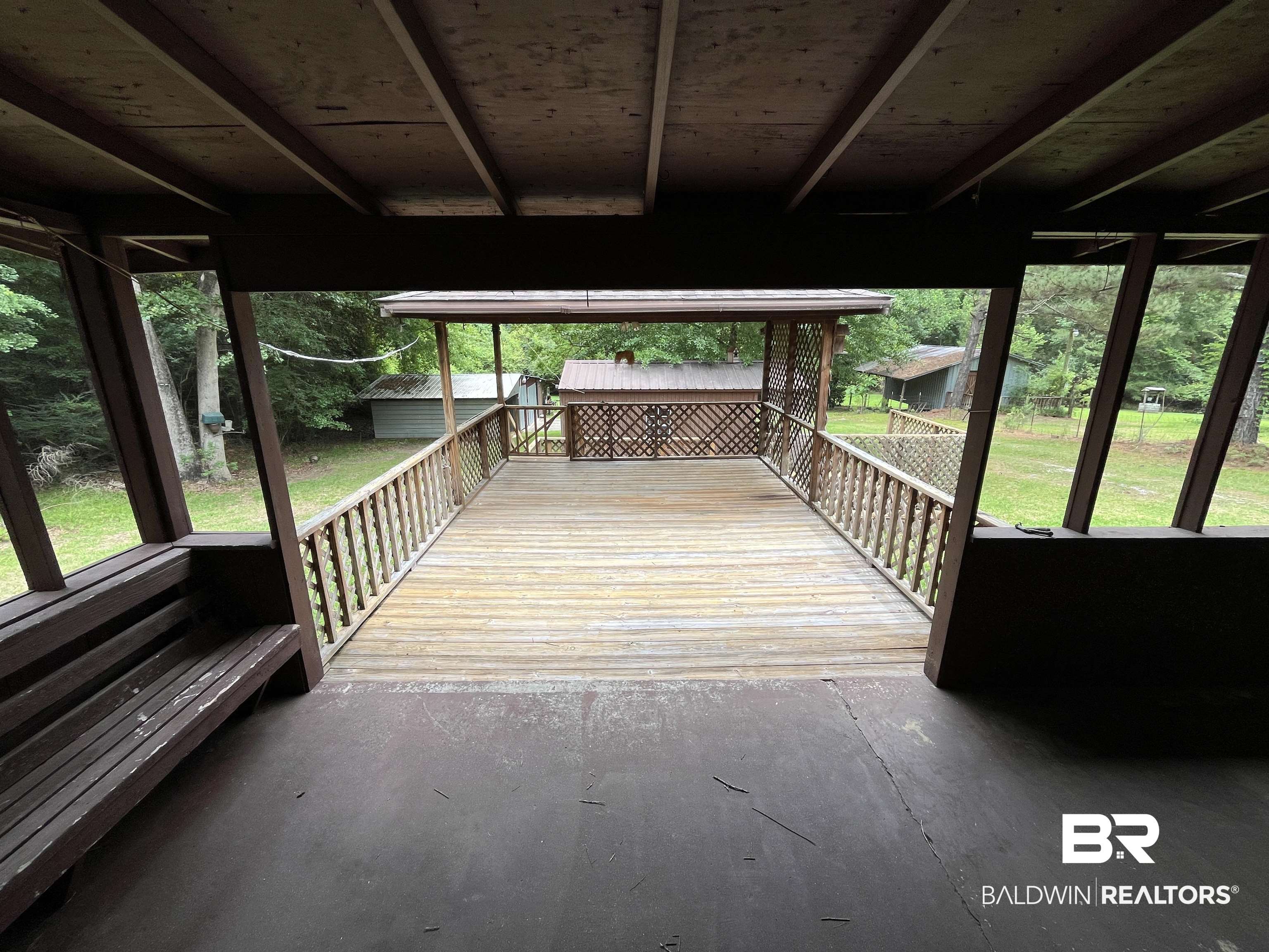 1905 Rockaway Creek Road Atmore, AL 36502 - Photo 14 of 23 Screened porch featuring a built-in bench and a wood-plank deck extending to an outdoor gazebo