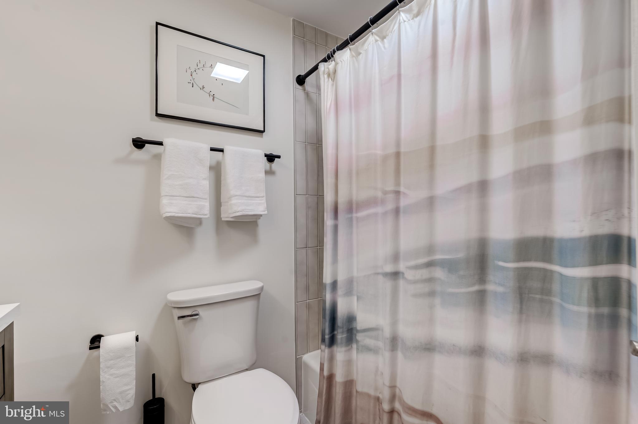 11926 Appling Valley Road Fairfax, VA 22030 - Photo 47 of 60 a bathroom with a toilet and a shower curtain