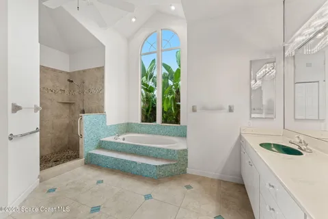 a spacious bathroom with a granite countertop tub sink and mirror