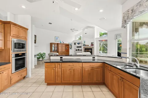 a kitchen with a sink counter top space stainless steel appliances and a large window
