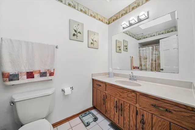 a bathroom with a granite countertop sink mirror vanity and toilet