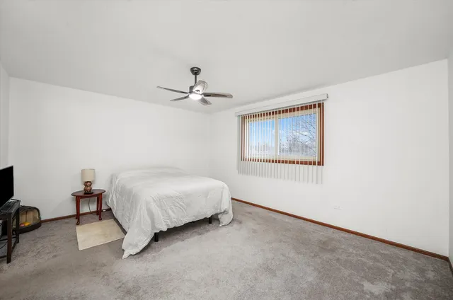 a spacious bedroom with a bed and a chandelier