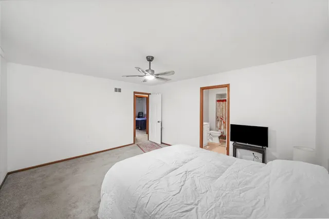 a bedroom with a bed and a ceiling fan
