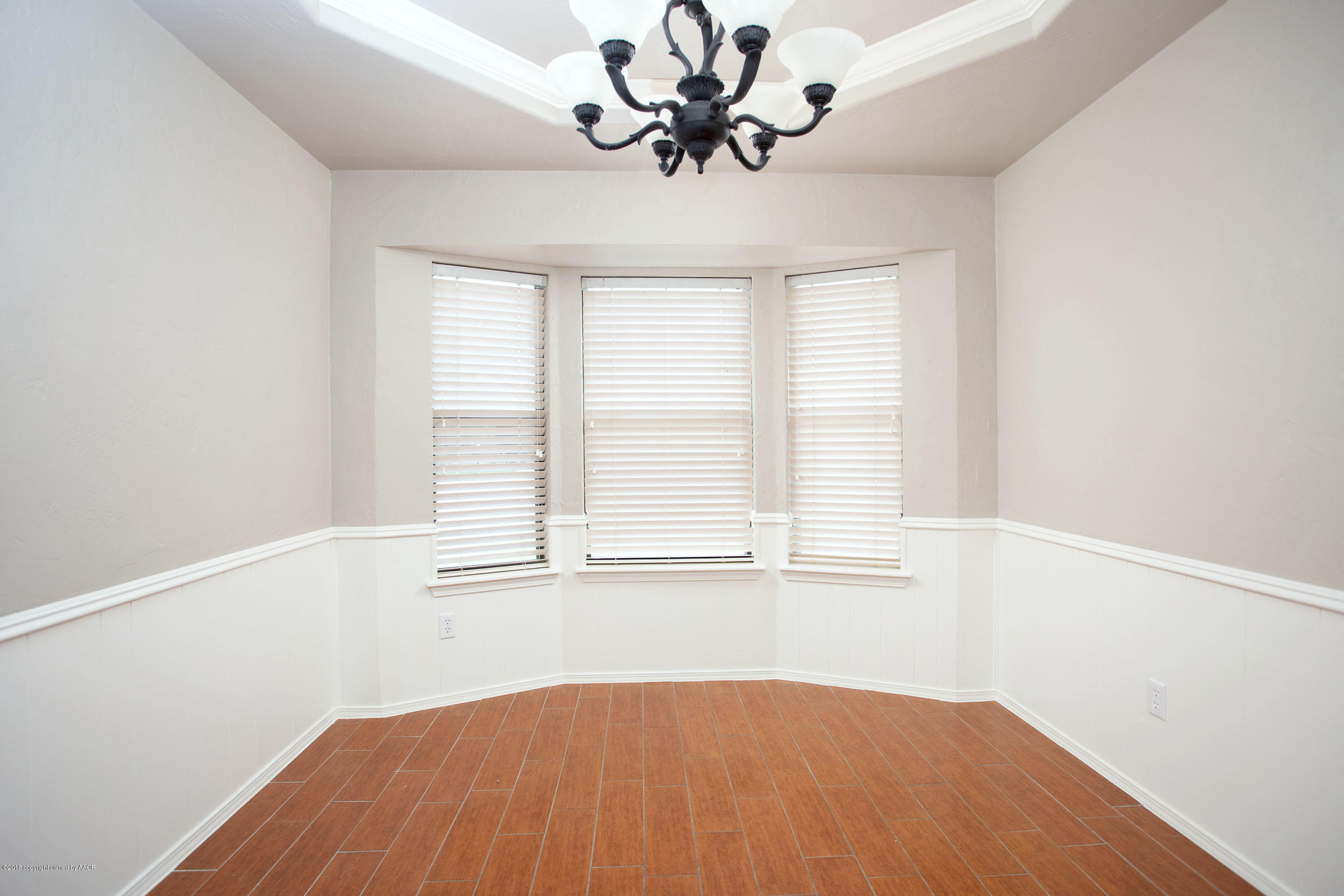 8209 Wrangler Trail Amarillo, TX 79110 - Photo 3 of 22 an empty room with a window and wooden floor