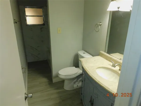 a white toilet sitting next to a bathroom sink and vanity