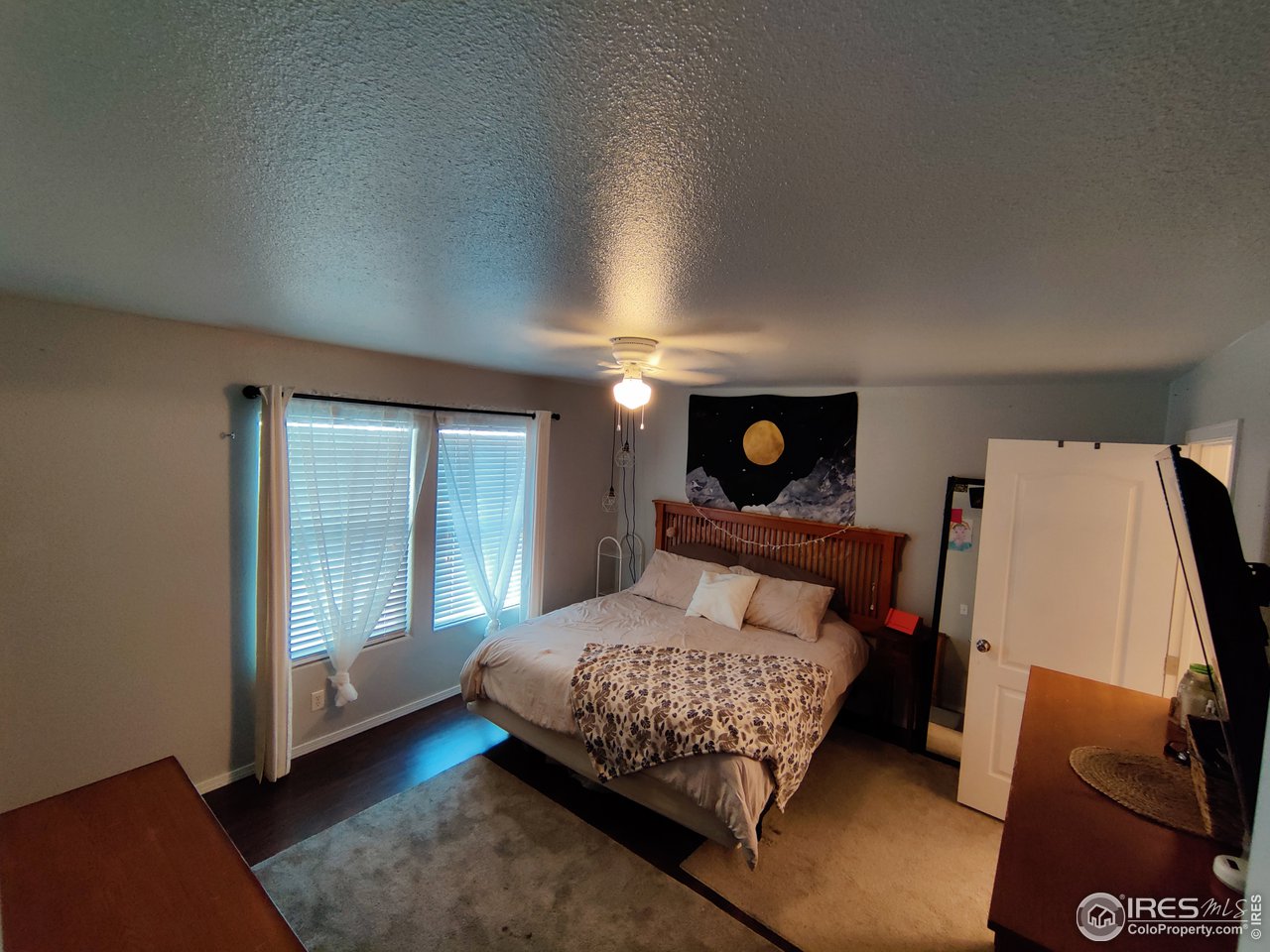 10567 Titan Avenue Firestone, CO 80504 - Photo 10 of 17 a bedroom with a bed and wooden floor