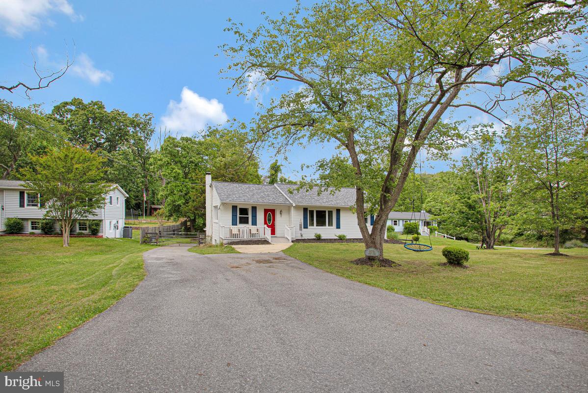 976 Shore Acres Road Arnold, MD 21012 - Photo 3 of 40 a front view of a house with a yard and trees