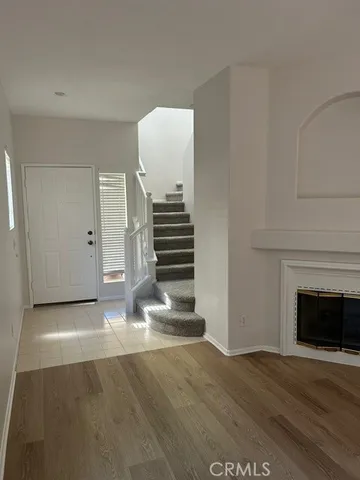 a view of empty room with stairs and wooden floor