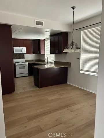 a kitchen with stainless steel appliances kitchen island granite countertop a stove a sink and a refrigerator