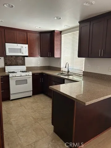a kitchen with stainless steel appliances granite countertop a sink a stove a refrigerator a sink and dishwasher