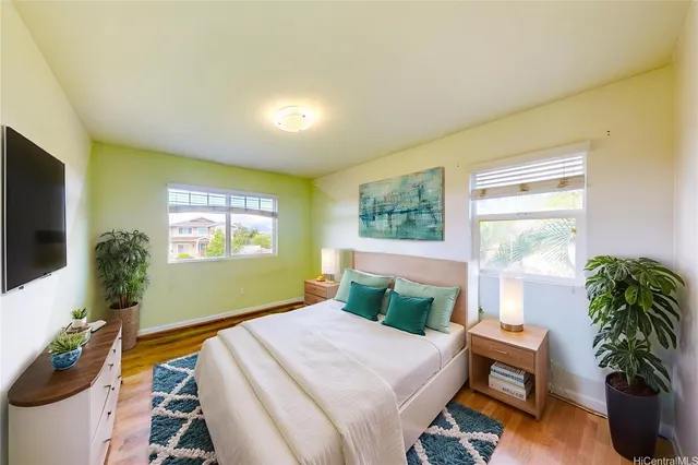 a bedroom with a bed and a potted plant